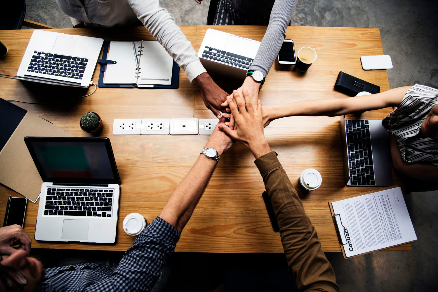 About Us 2 team business people stacking hands